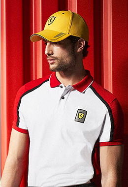 A three-quarter half-body man wears white, red and black Infinity polo shirt.