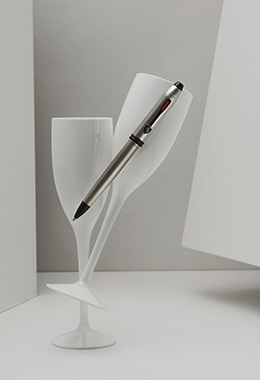 Scuderia Ferrari pen inside two glasses on a white geometric background.