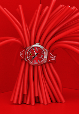 Children’s Academy watch with red dial and strap wrapped around some red tubes.