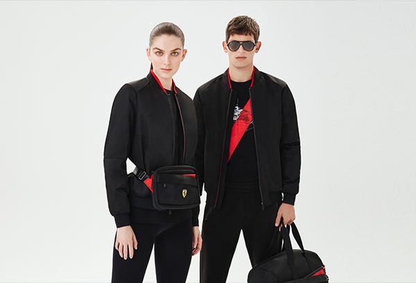A man and a woman wearing black and red Scuderia Ferrari clothes and accessories.