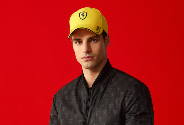CLOSE-UP OF A MAN WEARING YELLOW CAP WITH FERRARI SHIELD.