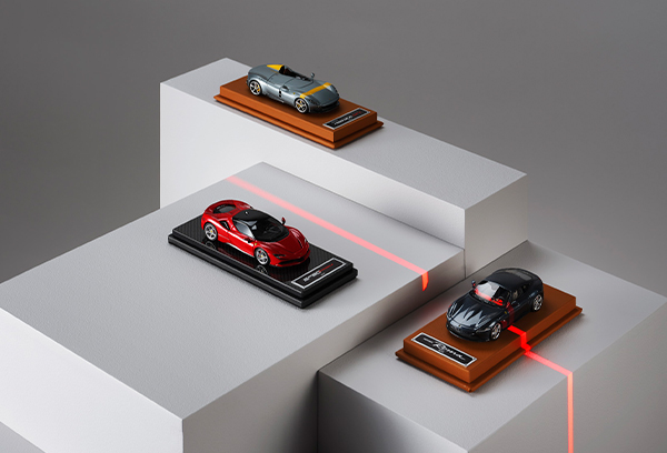 Scale reproductions of Ferrari cars on geometric blocks.
