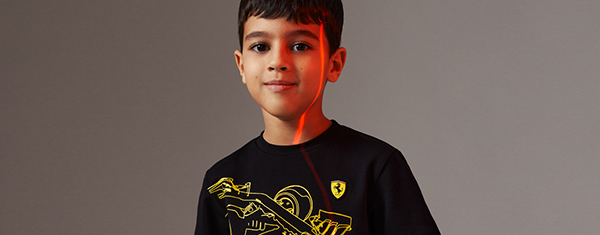 Half-length picture of a boy wearing Children’s mini-me black T-shirt with yellow Ferrari car print