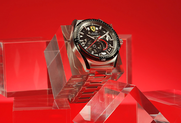 Steel automatic Pilota Evo watch with black skeleton dial on transparent geometric blocks.
