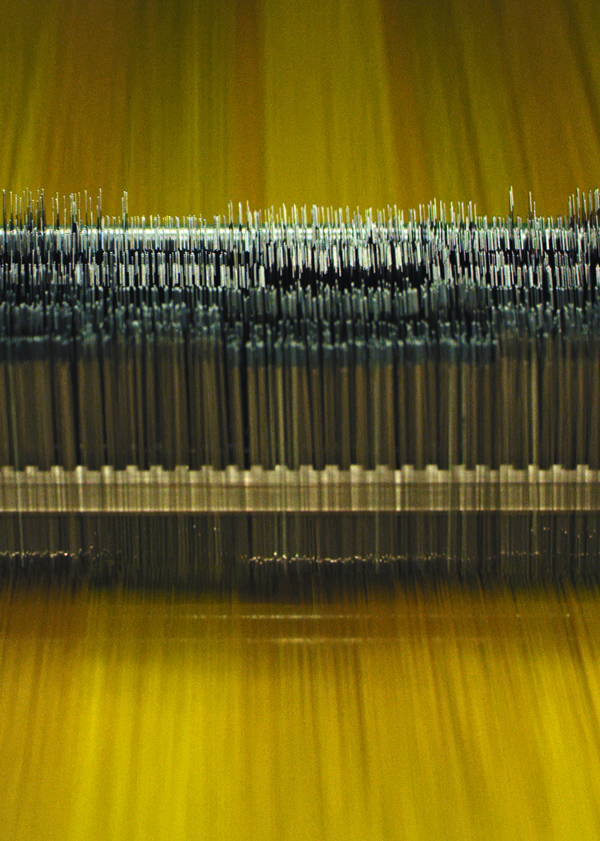 Textile machine producing yellow fabric with all-over Ferrari prancing horse pattern