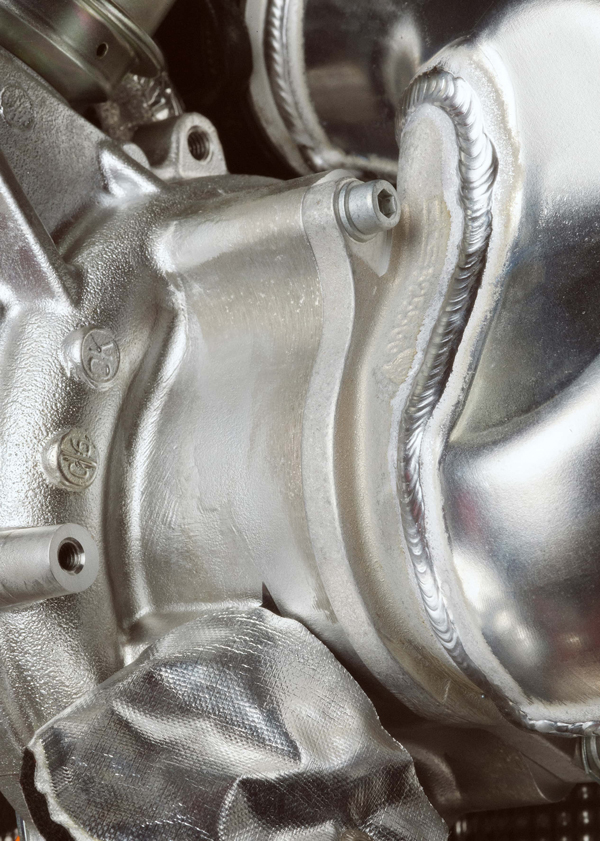 Close-up picture of metal prancing horse on back collar and a picture of Ferrari engine parts
