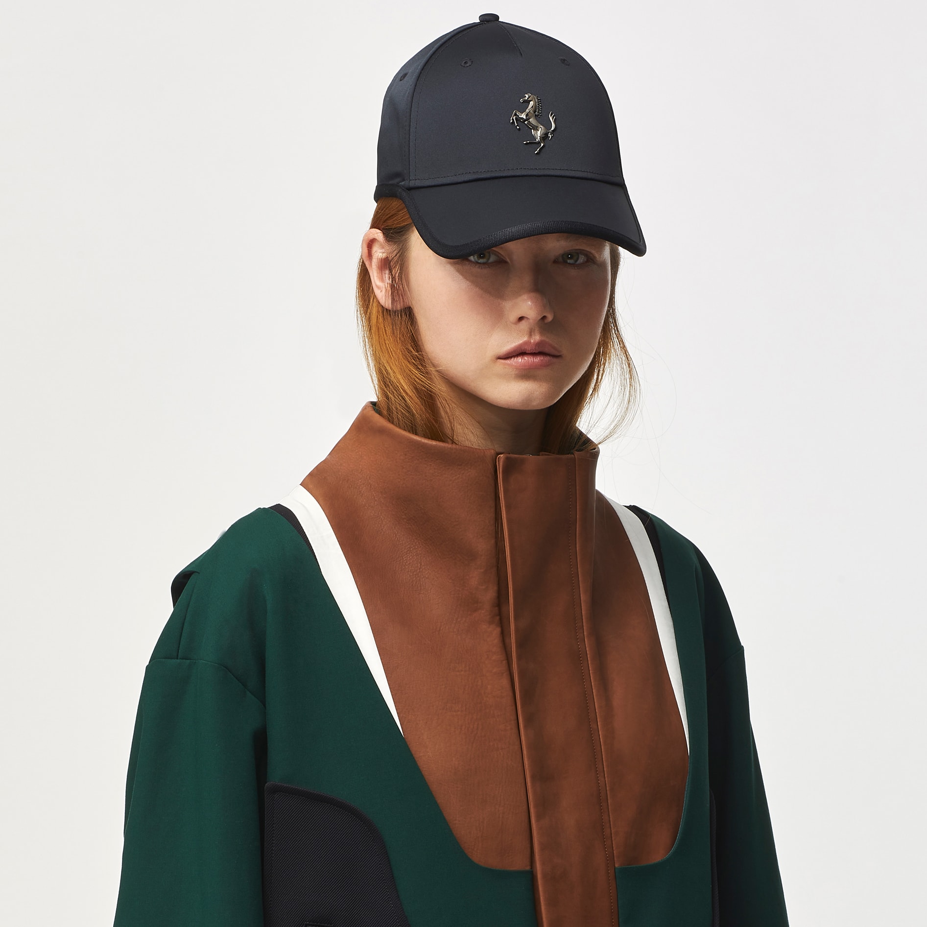 Half-length picture of a woman wearing a jacket in green cotton and brown leather with white details 