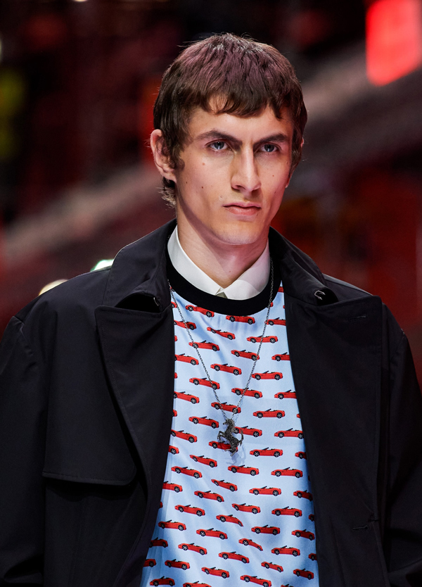 Half-length picture of a man walking the catwalk during the fashion show wearing all-over printed top