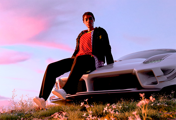 Full-length picture of a man sitting on the hood of a car wearing Ferrari clothes at sunset