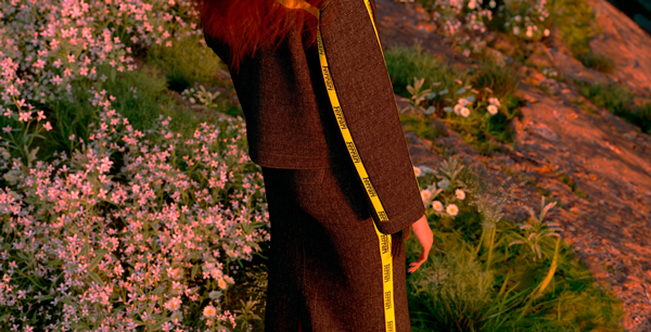Close-up picture of a woman wearing a denim suit in a flowery meadow