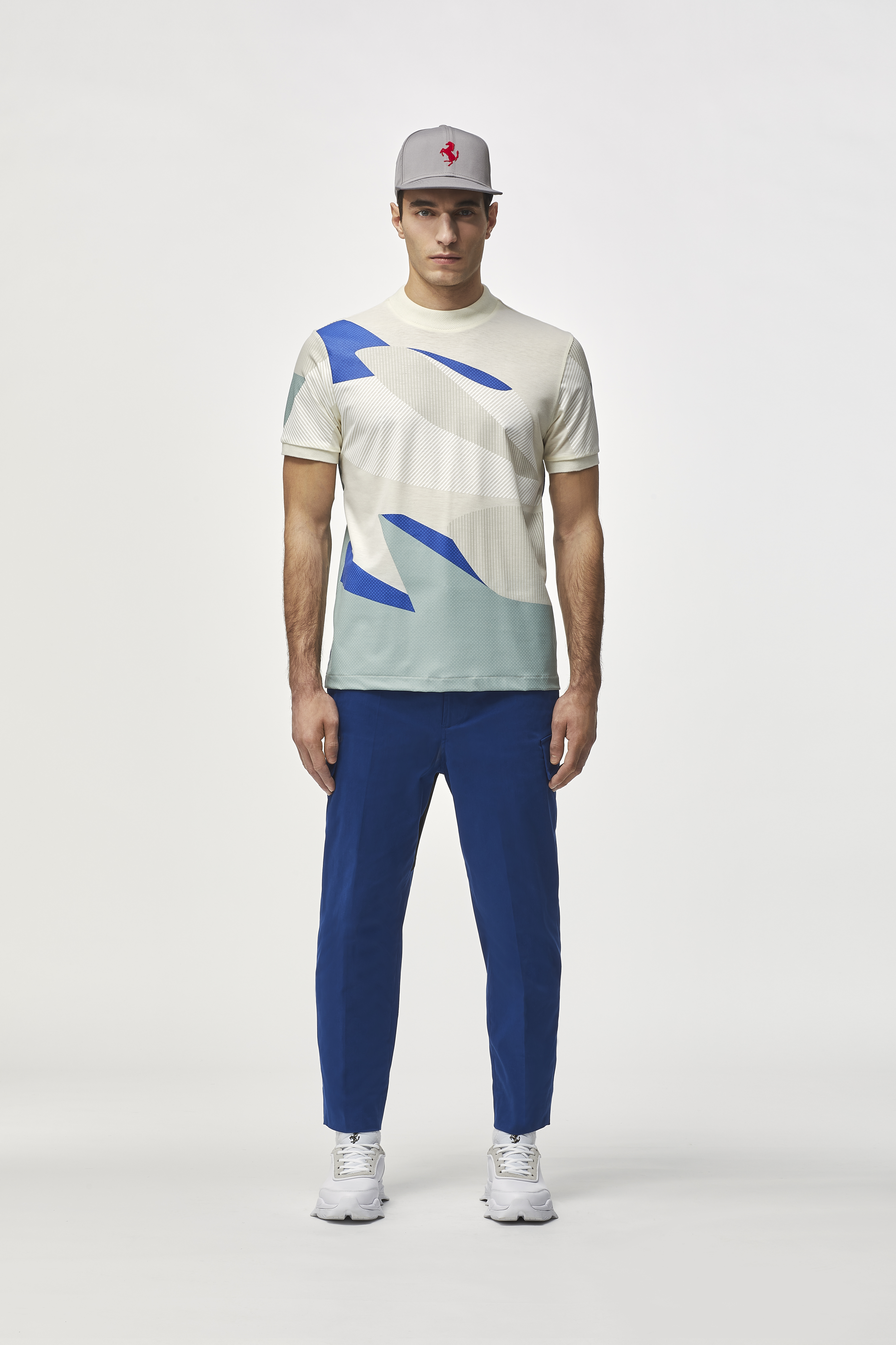 Men wearing white T-shirt with light gray, light blue and blue print, blue trousers and a gray hat.
