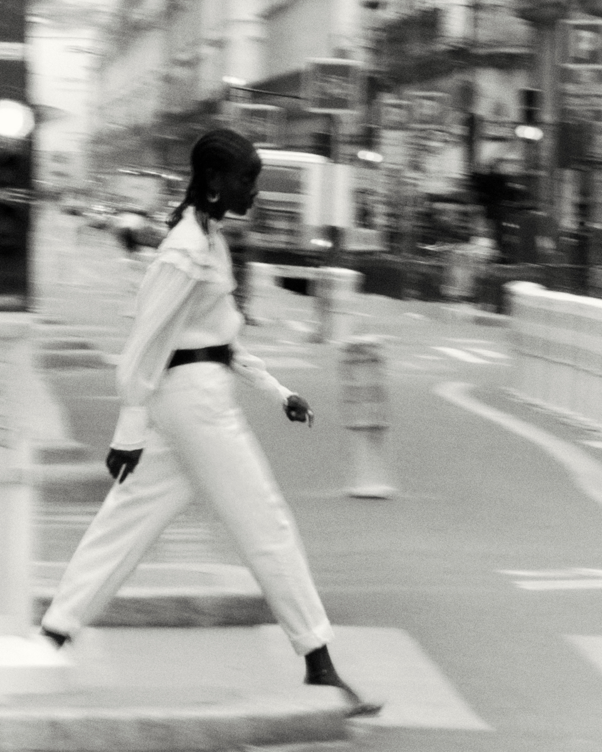 The model is wearing Isabel Marant Autumn-Winter 20 collection clothes while walking in the street.The image is black and white and has a blurred effect.