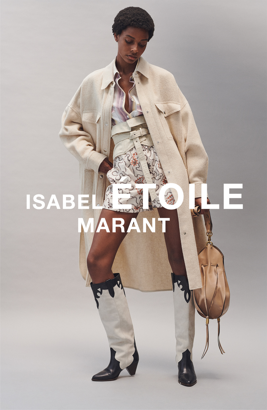 The model is wearing the Fontia coat, the Jalyne shirt, the Nawel short, the Prika belt, the Litz boots and the Taj bag from the Isabel Marant Étoile Spring 21 collection